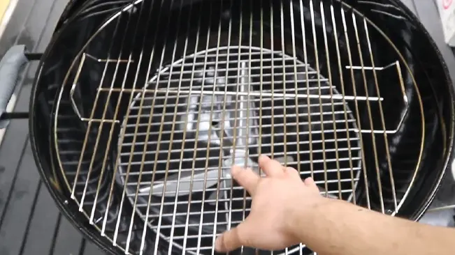 Person pointing at grill grate