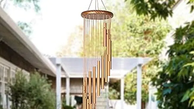 A wind chime hanging outdoors, used as a deterrent for carpenter bees through noise and vibrations.