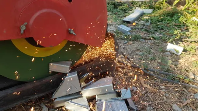 Sparks flying from machinery cutting metal, a risky activity that can spark wildfires if done in dry, flammable areas.