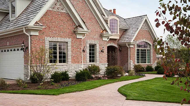 Brick house with manicured lawn and fire-resistant landscaping.