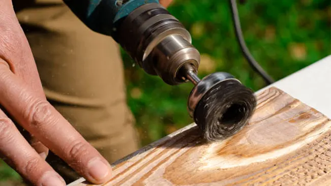 Person using a rotary tool to carve wood.