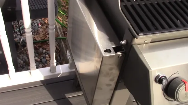 stainless steel grill sitting on top of a wooden deck