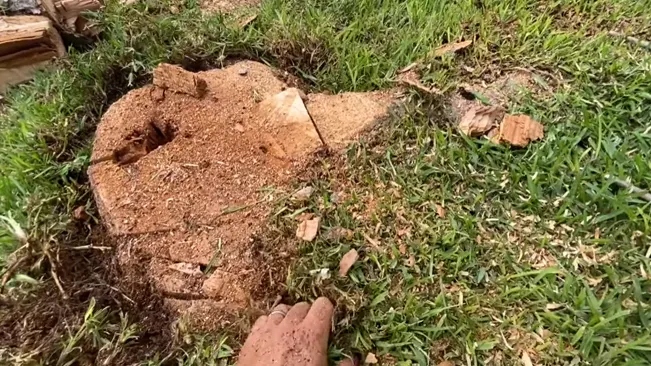 Hand pointing at a damaged ground with scattered bricks and debris