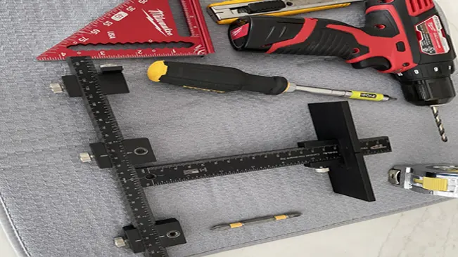 Collection of tools including a drill, screwdriver, and measuring tools on a gray surface