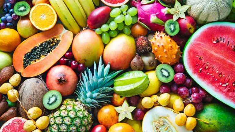 A colorful and diverse collection of fresh fruits including bananas, watermelon, grapes, pineapple, papaya, kiwi, oranges, mangoes, and various exotic fruits, all arranged in a vibrant display.