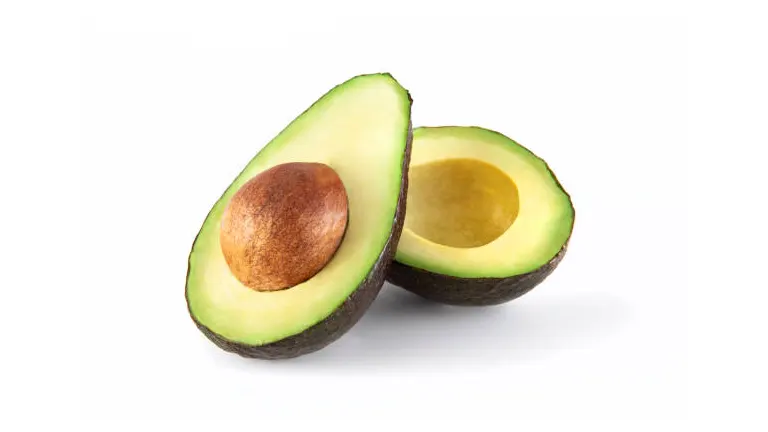 A halved avocado with one half showing the seed and the other half empty, displayed on a white background.
