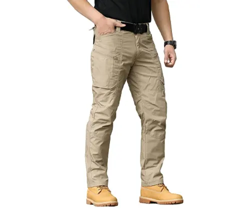 A person wearing light khaki hiking pants and yellow work boots, standing confidently with hands partially in pockets, showcasing a rugged outdoor style.