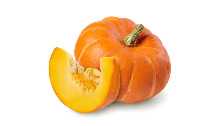 A whole orange pumpkin with a green stem, next to a cut wedge revealing the seeds and flesh, displayed on a white background.