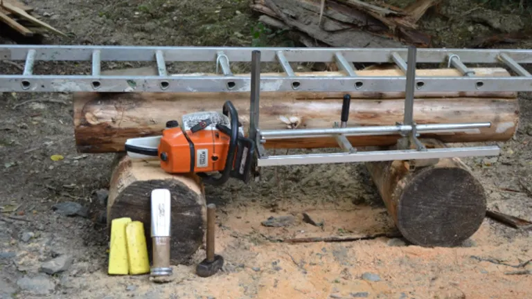 An orange chainsaw attached to a portable milling guide on a log, surrounded by forestry tools and another log, set in a natural, muddy environment.