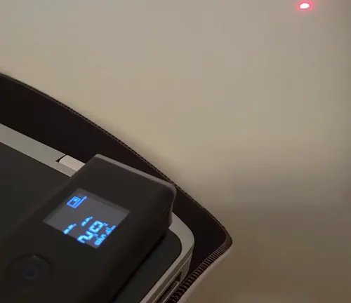 The display of the Dremel 3-in-1 Digital Measurement Tool showing a measurement in progress, with the laser point visible on a nearby surface.