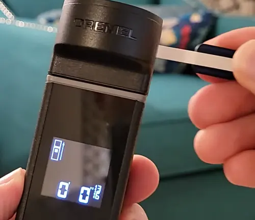 Close-up of the Dremel 3-in-1 Digital Measurement Tool's display showing digital readouts while measuring the length of a fabric with a wheel adapter.