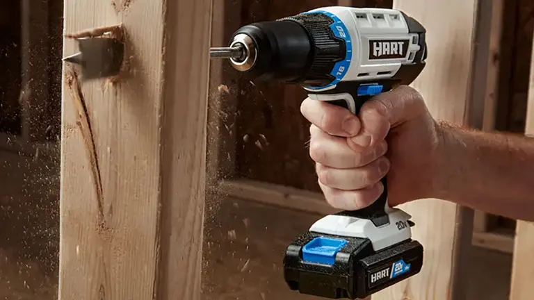 A person using a HART 20V impact driver to drive screws into a wooden beam.