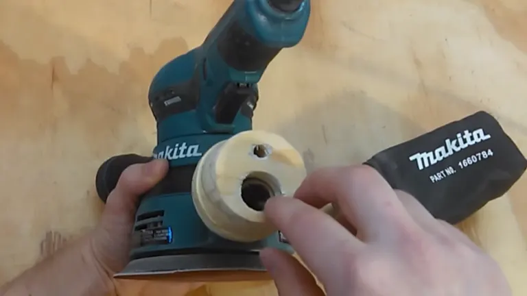 Hands holding a Makita power tool and a cylindrical accessory