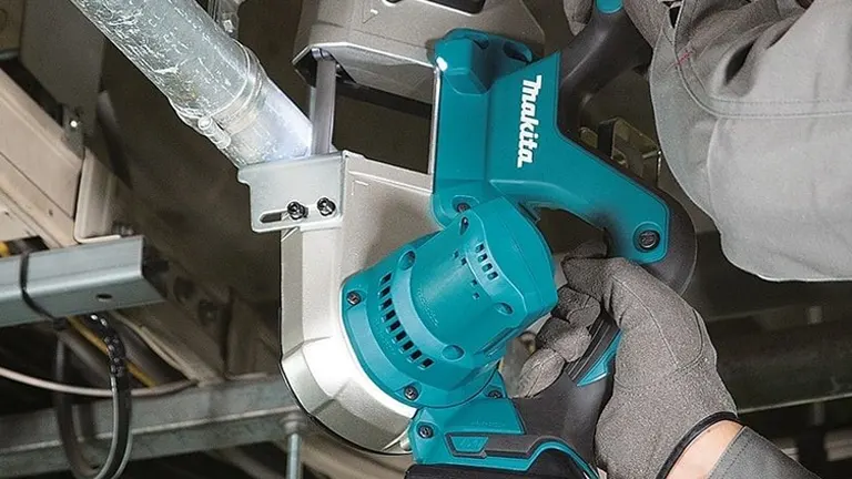 Person using Makita Band Saw 18V cutting metal pipe