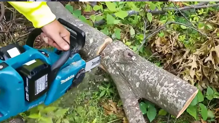 Person cutting a log using Makita XCU03PT Chainsaw in the forest
