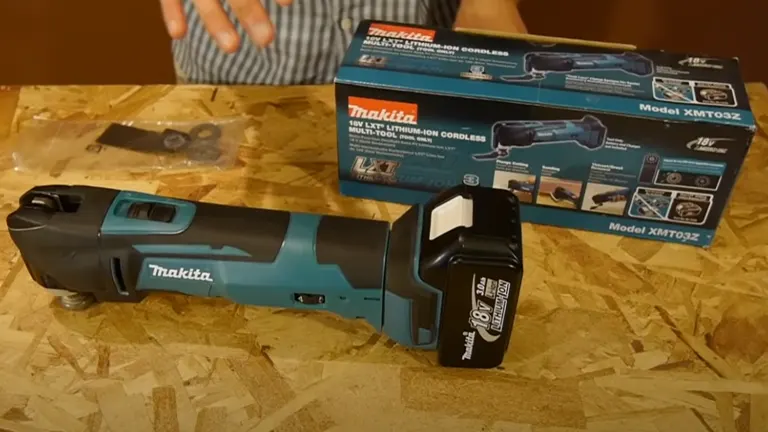 Makita XMT03Z Oscillating Multi-Tool displayed alongside its box and a cutting accessory on a wooden workbench.