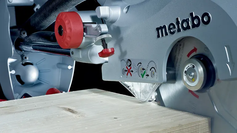 Close-up of Metabo KGS 315 Plus saw blade cutting through a wooden plank.