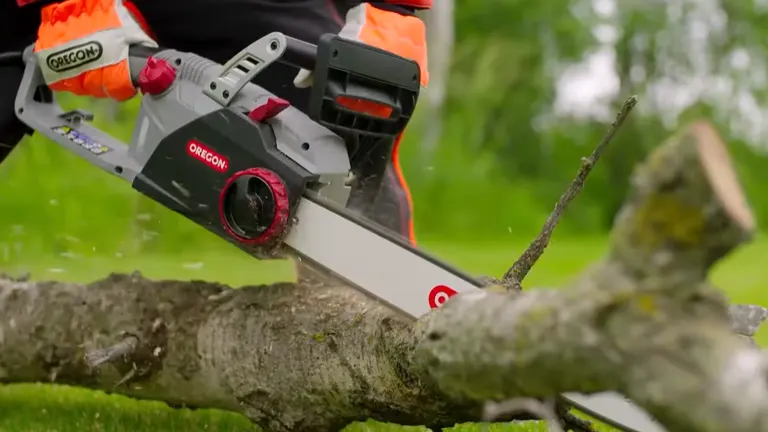 Person using an Oregon electric chainsaw to cut through a fallen tree.