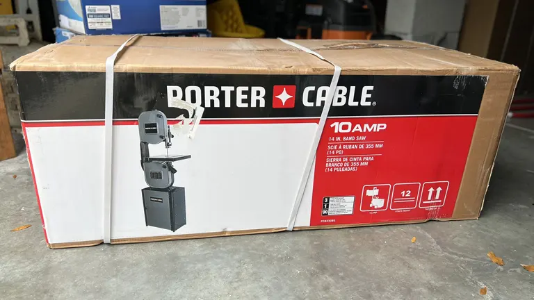 Box of the Porter Cable 14-inch bandsaw showing product packaging in a garage setting.