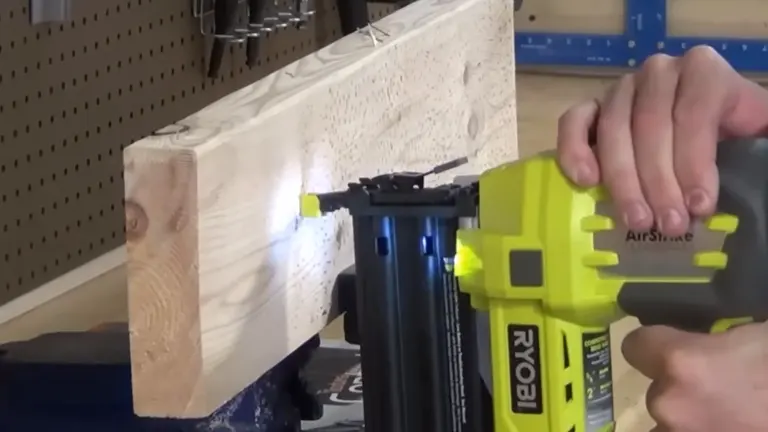 Action shot of the Ryobi P320 Airstrike Brad Nailer driving a nail into a wooden board.