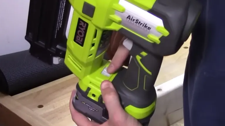 Ryobi P320 Airstrike Brad Nailer with a person demonstrating the grip and trigger mechanism.