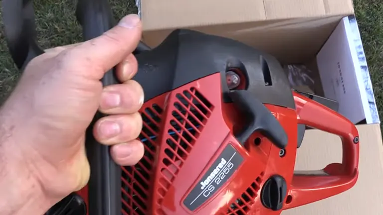 Person lifting the Jonsered CS2255 out of the box