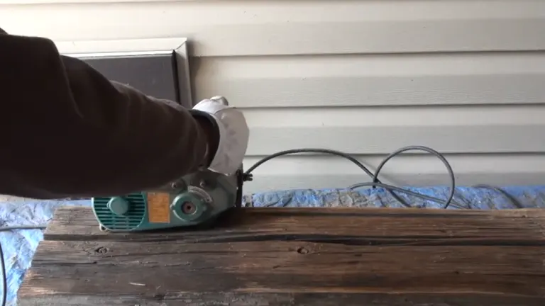 Action shot of Makita 9741 Wheel Sander smoothing an aged wooden beam.