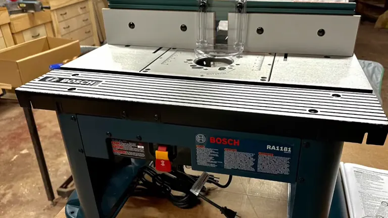 Close-up of the Bosch RA1181 router table's work surface, featuring measurement markings and router mounting area.