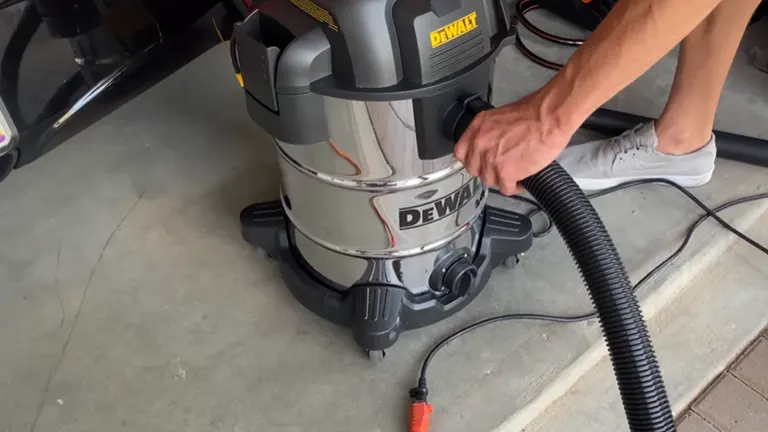 Close-up of the DeWalt vacuum highlighting the hose attachment and control settings.

