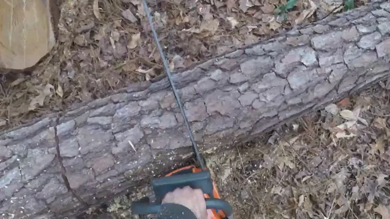 Husqvarna 390 XP chainsaw cutting through a log on the ground in a wooded area.