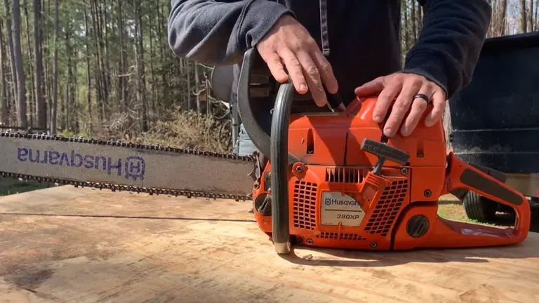 A person holding the handle of Husqvarna 390 XP chainsaw placed on a wooden surface.