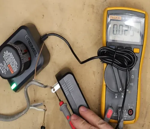 Multimeter connected to a transformer testing its output with displayed reading.
