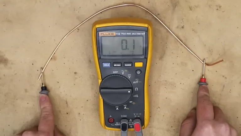Multimeter displaying 0.1 on screen, measuring resistance with two probes held by hands on a plain background.