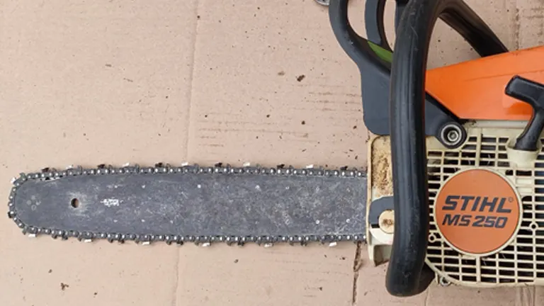 Image of a worn chainsaw lying on a flat surface, showing extensive wear and damage to the bar.
