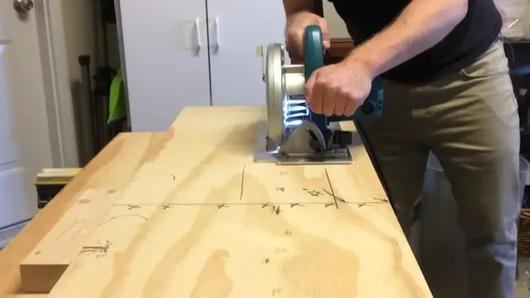 Person using a circular saw to cut a large wooden board in a workshop.
