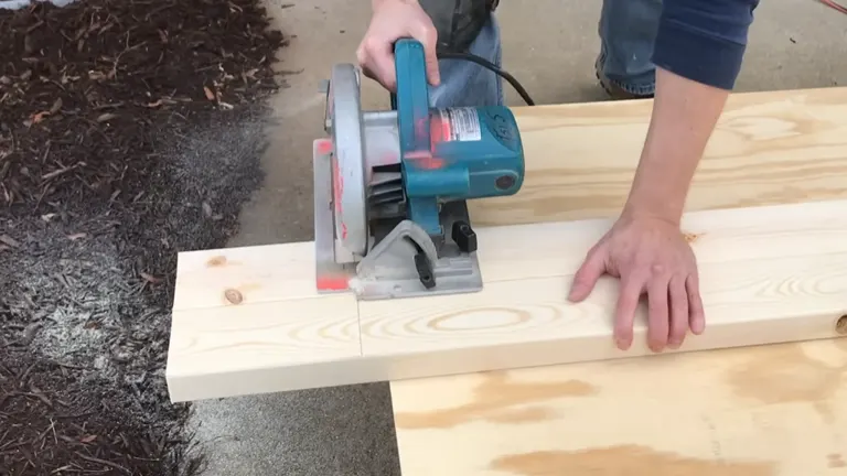 Circular saw cutting through a wooden plank on an outdoor workbench.