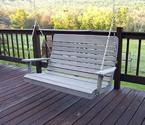 Wooden porch swing with gray slats, hanging from chains on a deck.