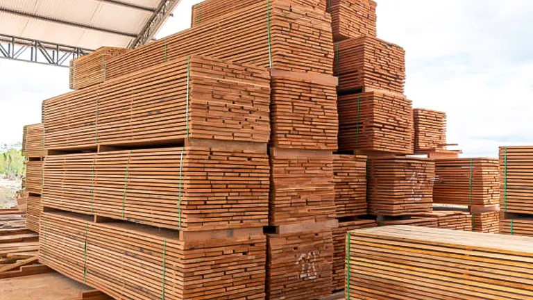 Large stacks of neatly arranged wooden planks in a warehouse.