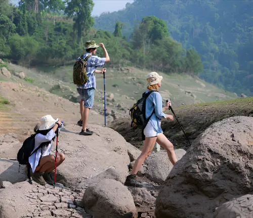 Three hikers navigating rocky terrain.