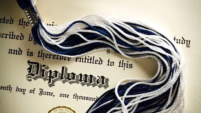 Close-up of a diploma with graduation tassels, representing associate degrees and diplomas.