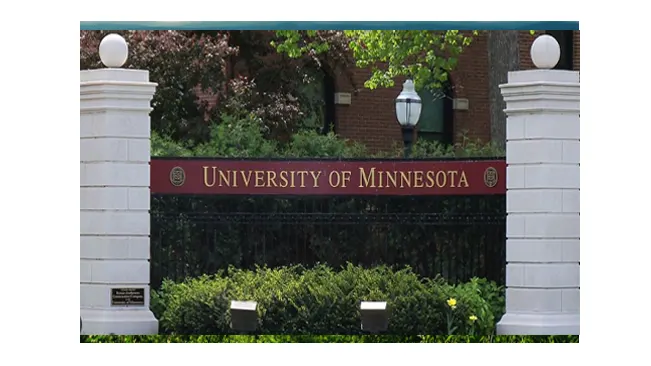 University of Minnesota sign with white columns and greenery.