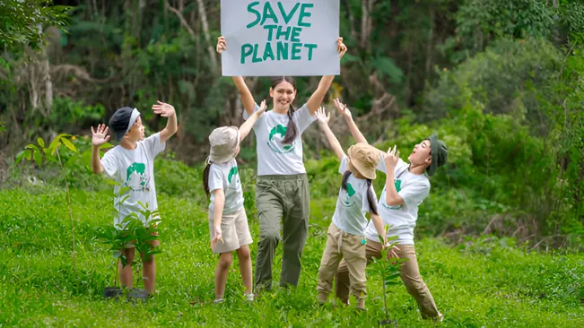 A group of children participating in forest ecosystem restoration, holding a 'Save the Planet' sign, 