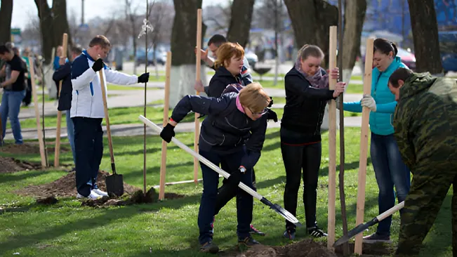 Community members working together to plant trees, illustrating engaging communities in restoration efforts.