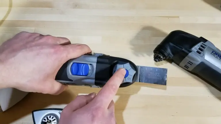 Close-up of a Dremel oscillating tool showing the blue speed control button.