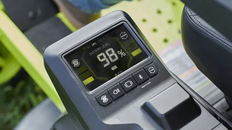 Close-up of the LCD screen on a Ryobi 80V mower displaying battery level and other controls.