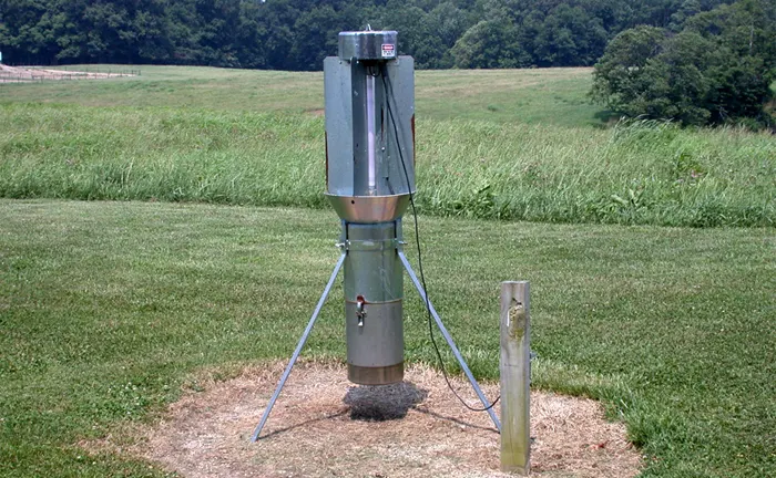 Weather monitoring station in a field, part of sustainable forest management to assess wildfire risks.