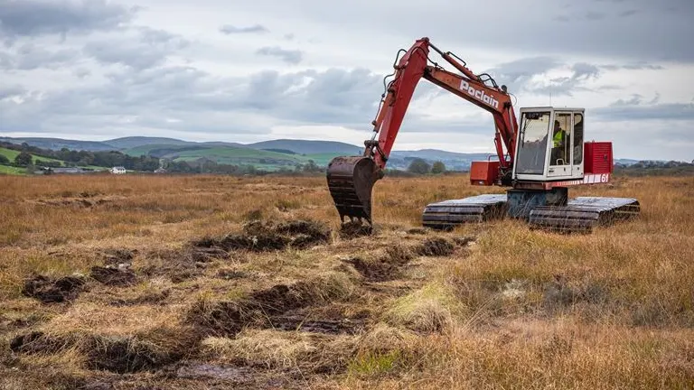 Excavator restoring a degraded peatland area.