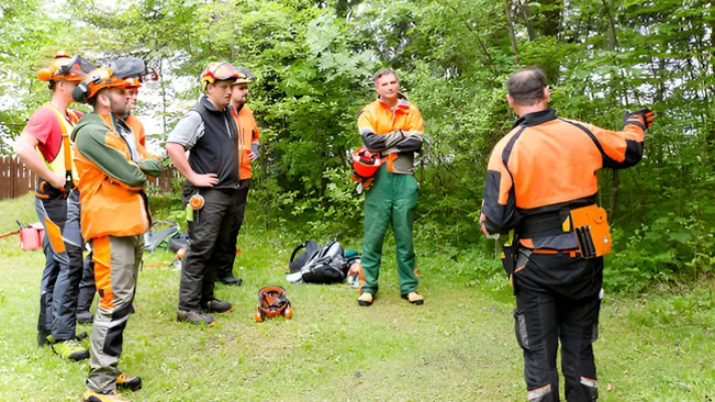 Group of workers in safety gear receiving instructions for wildlife habitat management.







