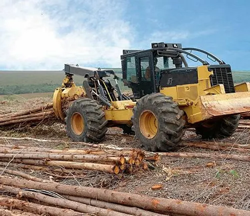 Skidder machine dragging felled trees to a collection point, efficiently handling rugged terrain and heavy loads.