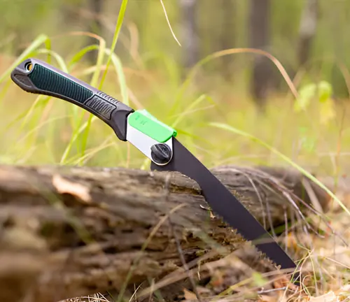 A folding pruning saw, an essential hand tool for smaller tree thinning operations, lying on a felled tree.